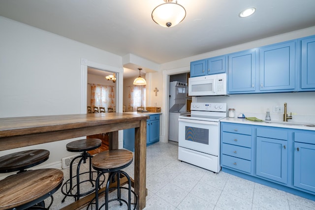 kitchen with blue cabinetry, sink, an inviting chandelier, decorative light fixtures, and white appliances