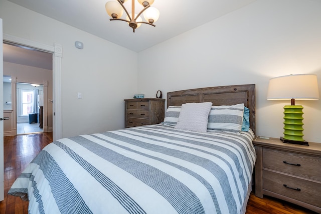 bedroom featuring dark wood-type flooring and an inviting chandelier