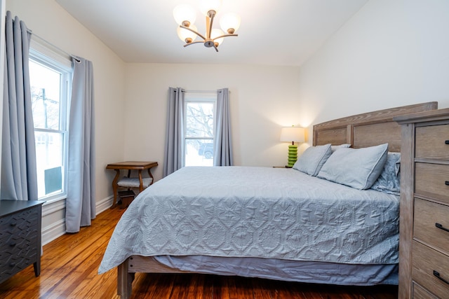 bedroom with hardwood / wood-style floors and a chandelier