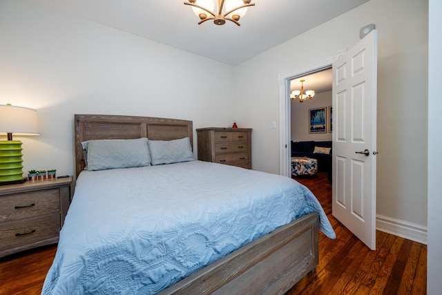 bedroom with dark hardwood / wood-style flooring and a chandelier