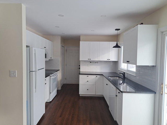 kitchen featuring white appliances, white cabinetry, hanging light fixtures, and sink