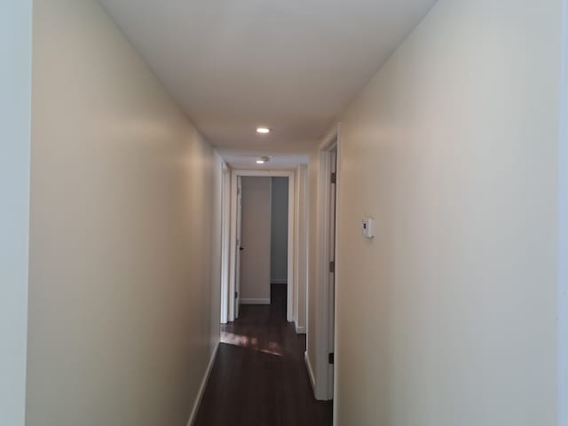 corridor with dark hardwood / wood-style flooring