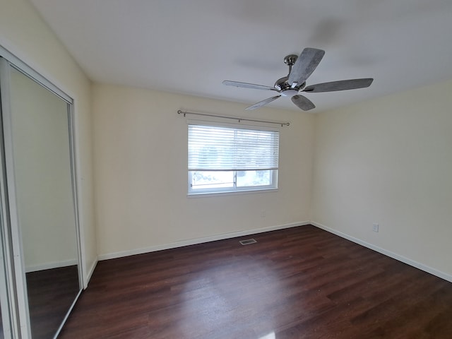 unfurnished room with dark hardwood / wood-style flooring and ceiling fan