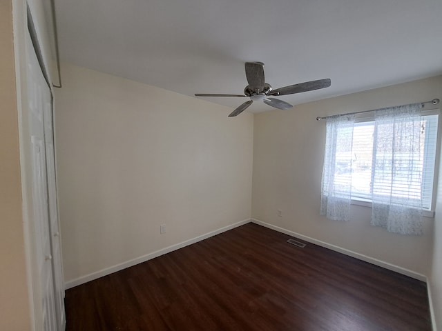 unfurnished room with dark wood-type flooring and ceiling fan