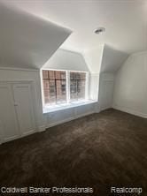 bonus room featuring lofted ceiling and dark carpet