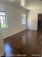 empty room with a healthy amount of sunlight and dark hardwood / wood-style floors