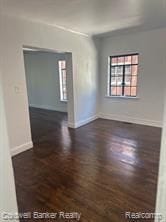 empty room with dark wood-type flooring