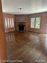 unfurnished living room featuring a large fireplace and dark hardwood / wood-style floors