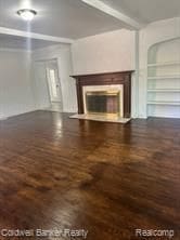 unfurnished living room with built in shelves, beamed ceiling, and dark hardwood / wood-style floors