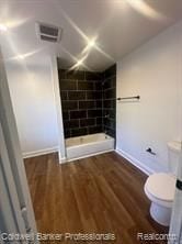 bathroom featuring toilet, walk in shower, and hardwood / wood-style flooring