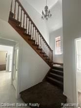 stairs featuring a chandelier