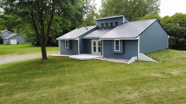 rear view of property with french doors and a lawn