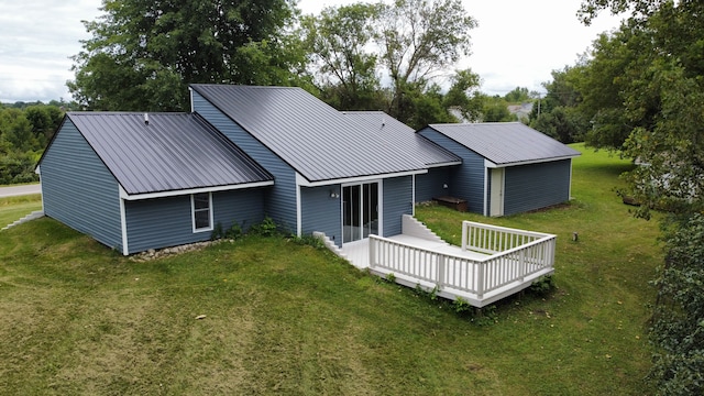 rear view of property featuring a deck and a yard