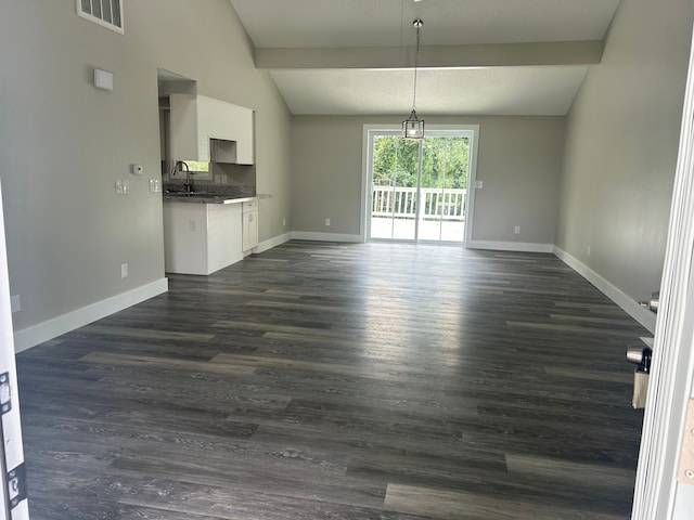 interior space featuring vaulted ceiling with beams and dark hardwood / wood-style floors