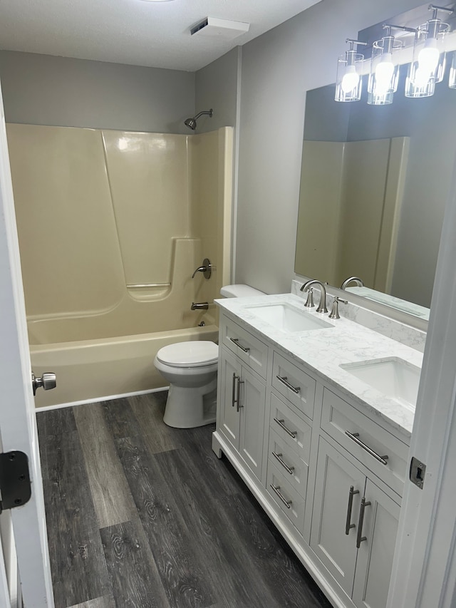 full bathroom featuring toilet, hardwood / wood-style flooring, shower / tub combination, and vanity