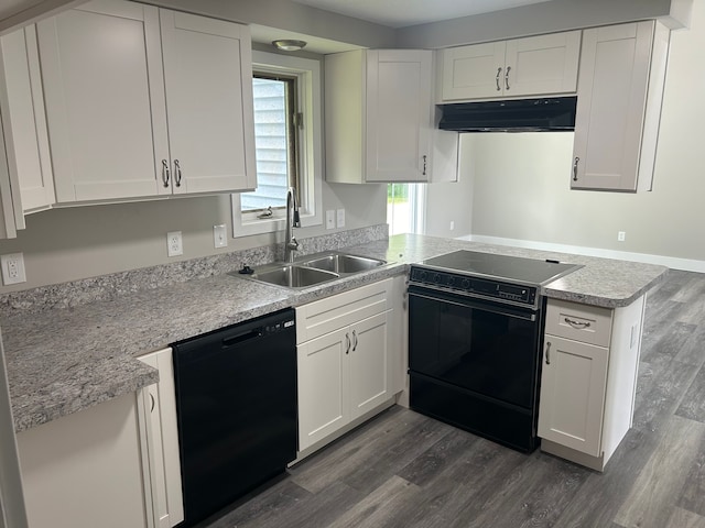 kitchen with kitchen peninsula, dark wood-type flooring, black appliances, white cabinets, and sink