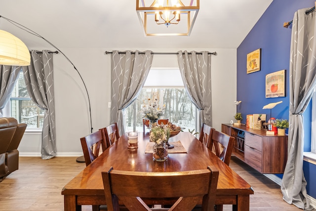 dining area with a notable chandelier and light hardwood / wood-style flooring