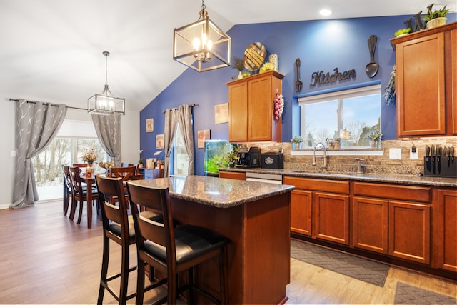 kitchen with sink, pendant lighting, a chandelier, and tasteful backsplash