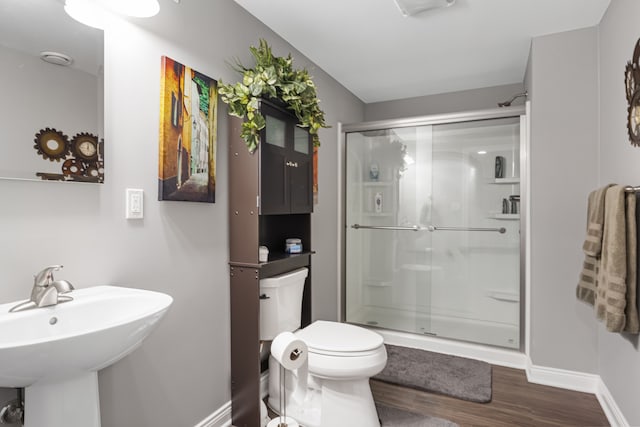 bathroom with toilet, an enclosed shower, sink, and wood-type flooring