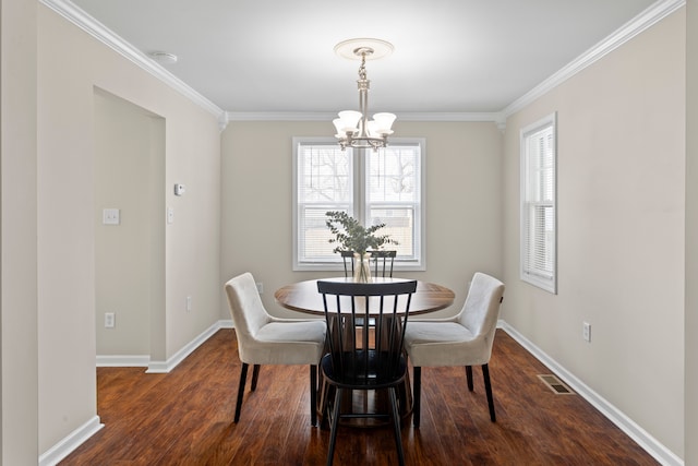 dining area with dark hardwood / wood-style flooring, ornamental molding, and a chandelier