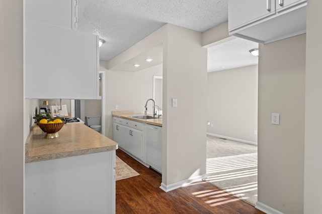 kitchen featuring sink, white dishwasher, white cabinetry, dark wood-type flooring, and a textured ceiling