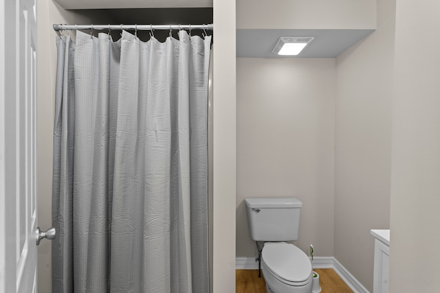 bathroom with toilet, vanity, and hardwood / wood-style floors