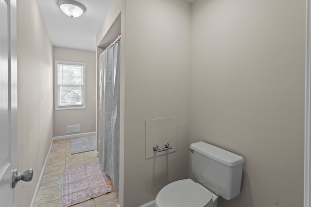 bathroom featuring toilet and tile patterned flooring