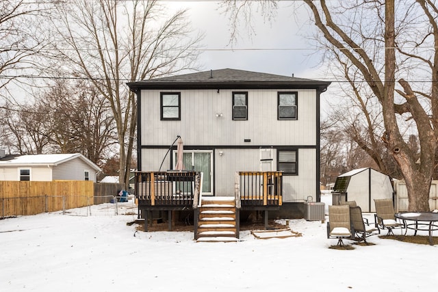 snow covered property with a wooden deck and central air condition unit