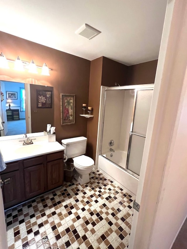 full bathroom with combined bath / shower with glass door, vanity, and toilet