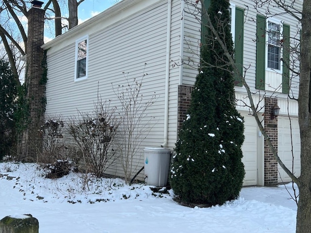 snow covered property featuring a garage