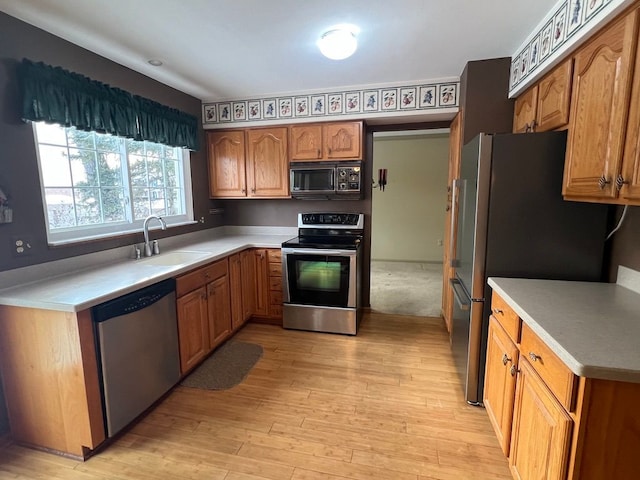 kitchen featuring appliances with stainless steel finishes, light wood-type flooring, and sink