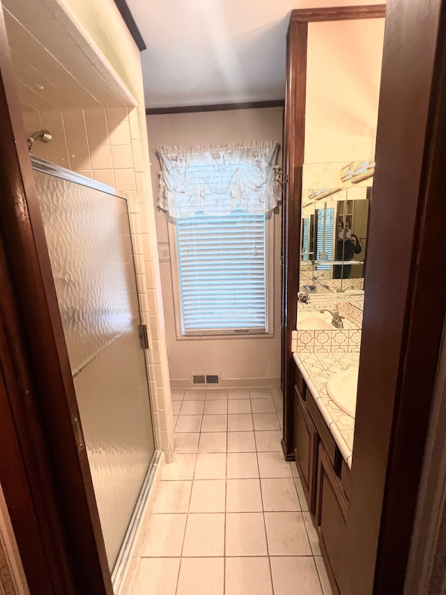 bathroom with vanity, walk in shower, tile patterned floors, and crown molding