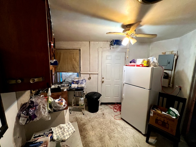 kitchen featuring electric panel, white fridge, and ceiling fan