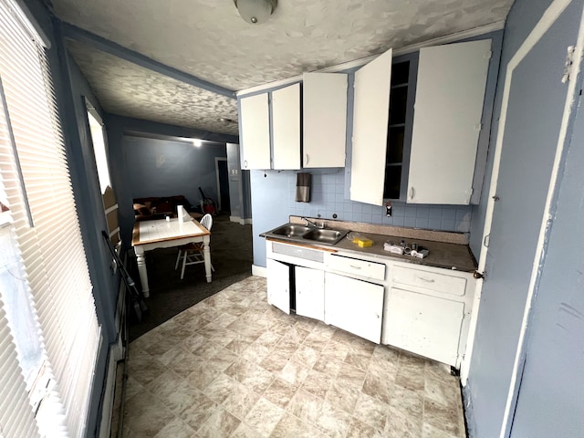 kitchen with white cabinets, backsplash, and sink