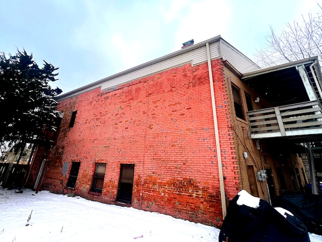 snow covered property with a balcony