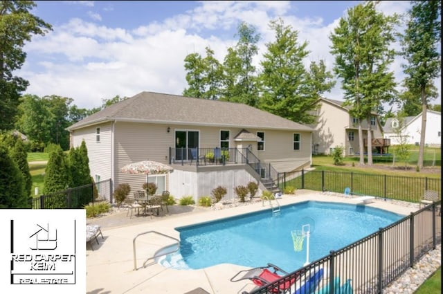 view of swimming pool featuring a patio and a diving board