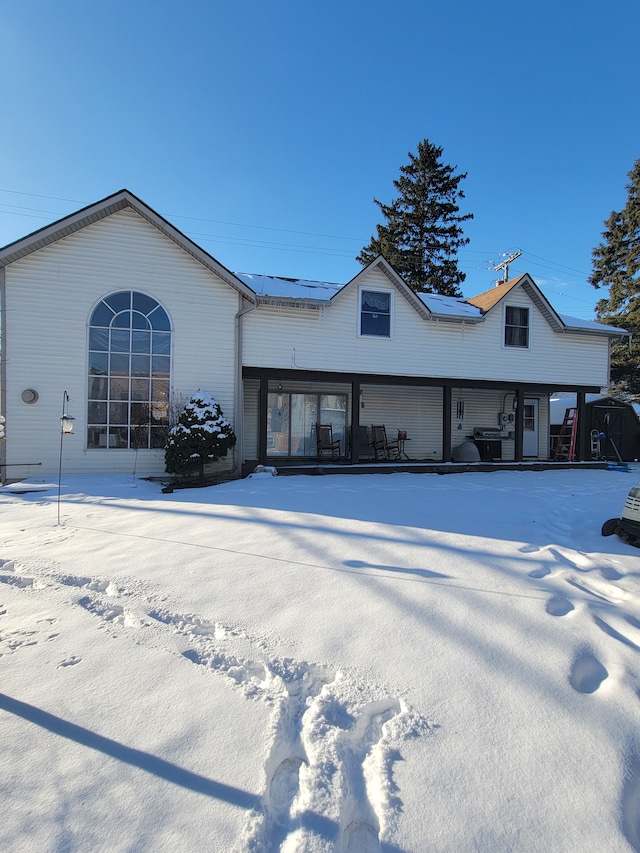 view of snow covered back of property