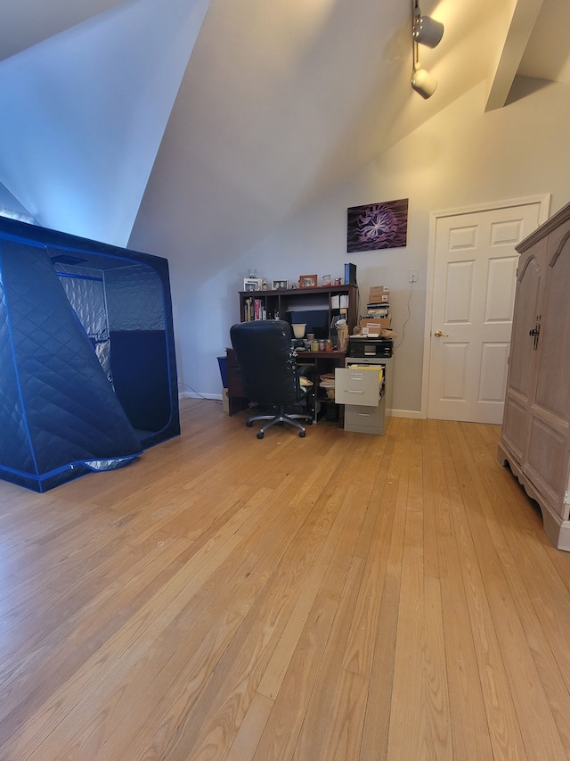 home office with light hardwood / wood-style floors and vaulted ceiling