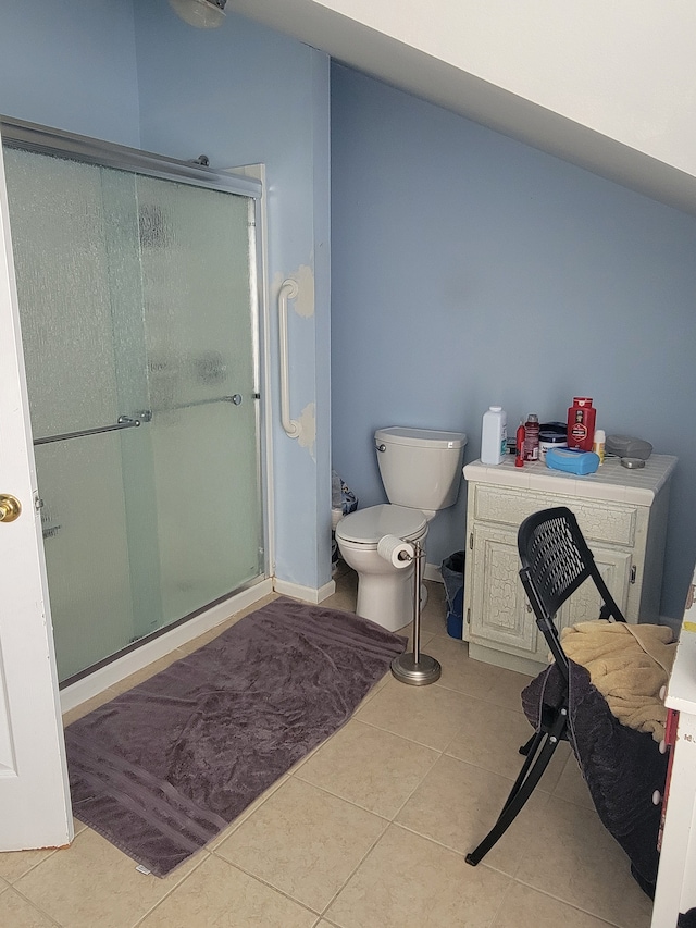 bathroom featuring tile patterned flooring, a shower with door, and toilet