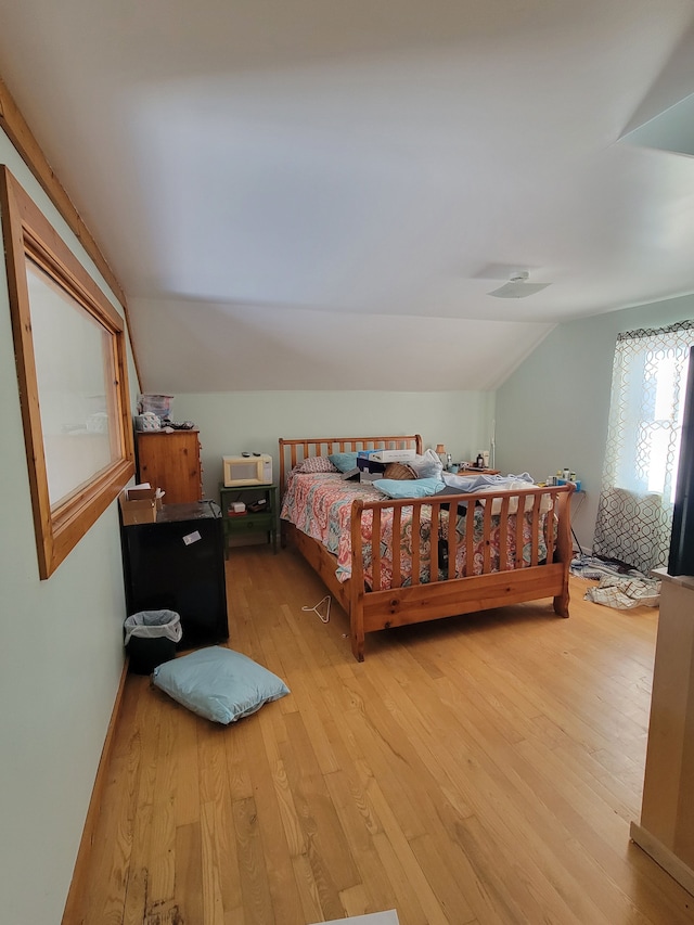 bedroom with light hardwood / wood-style floors and vaulted ceiling