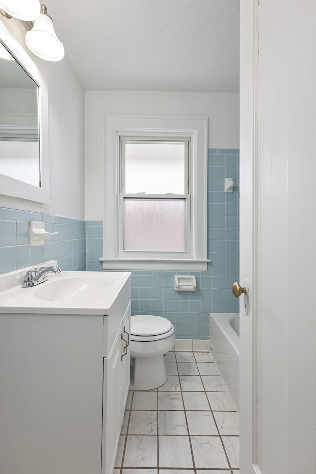 bathroom with toilet, tile patterned flooring, a bath, and vanity