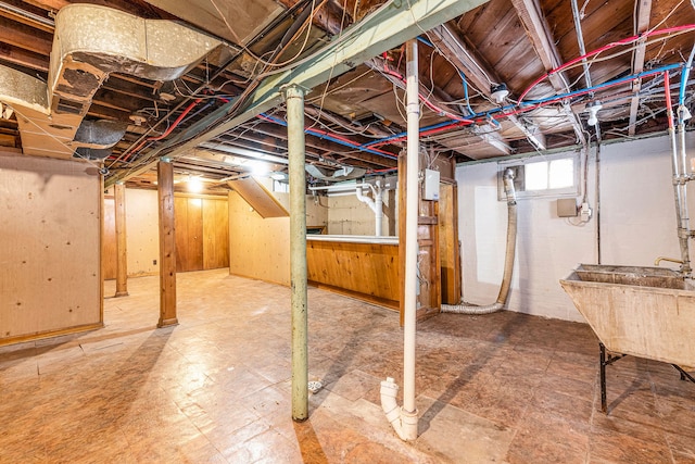 basement with sink and wood walls