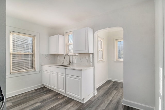 kitchen with sink, white cabinetry, backsplash, and plenty of natural light