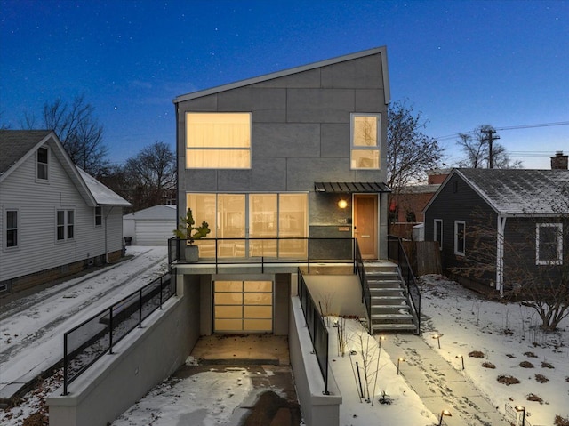 snow covered house featuring a garage