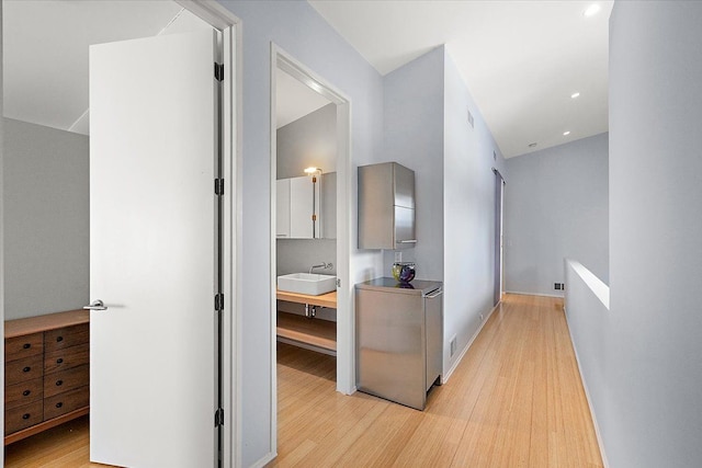 hall featuring sink and light hardwood / wood-style flooring