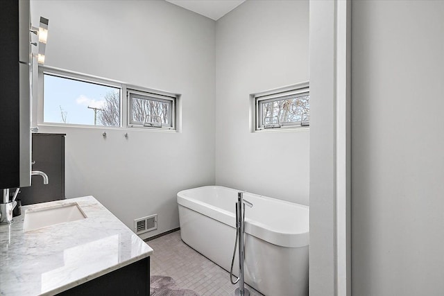 bathroom with vanity and a bath