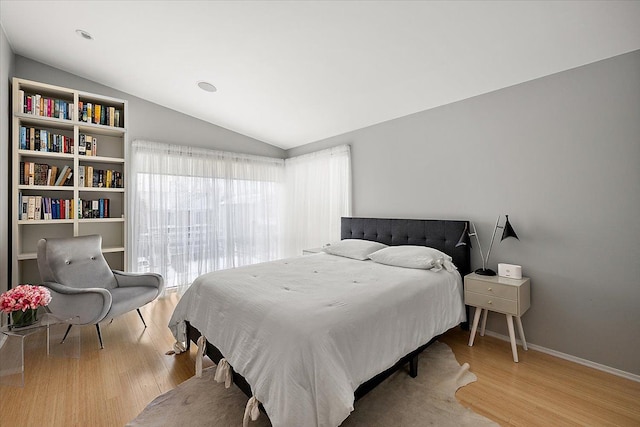 bedroom with lofted ceiling and light hardwood / wood-style flooring