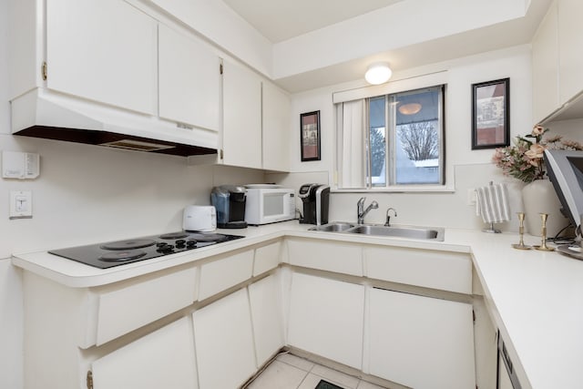 kitchen with black electric cooktop, white cabinets, light tile patterned floors, and sink