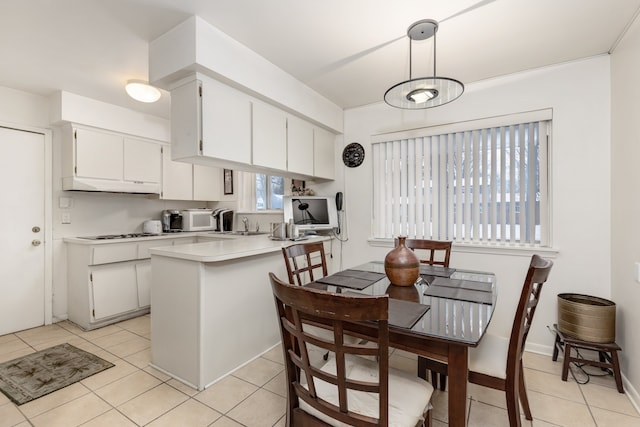 kitchen with pendant lighting, white cabinetry, kitchen peninsula, and light tile patterned floors