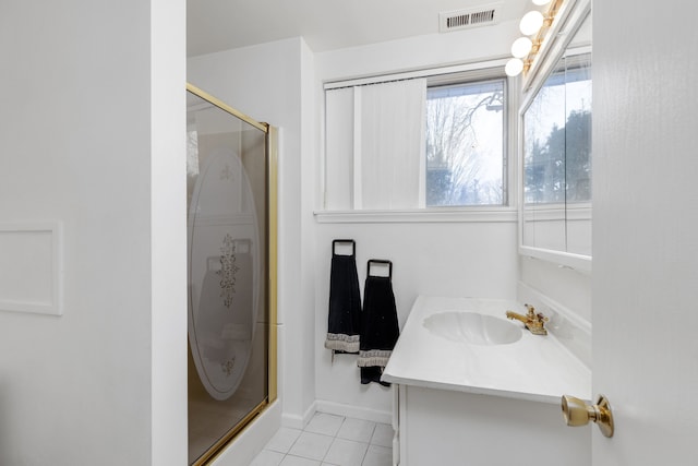 bathroom with a shower with door, tile patterned floors, and vanity